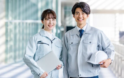 笑顔でこちらを見ている男女のエンジニアの写真。